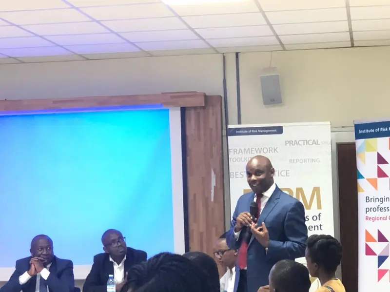 Samuel Kibaara speaking, microphone in hand.